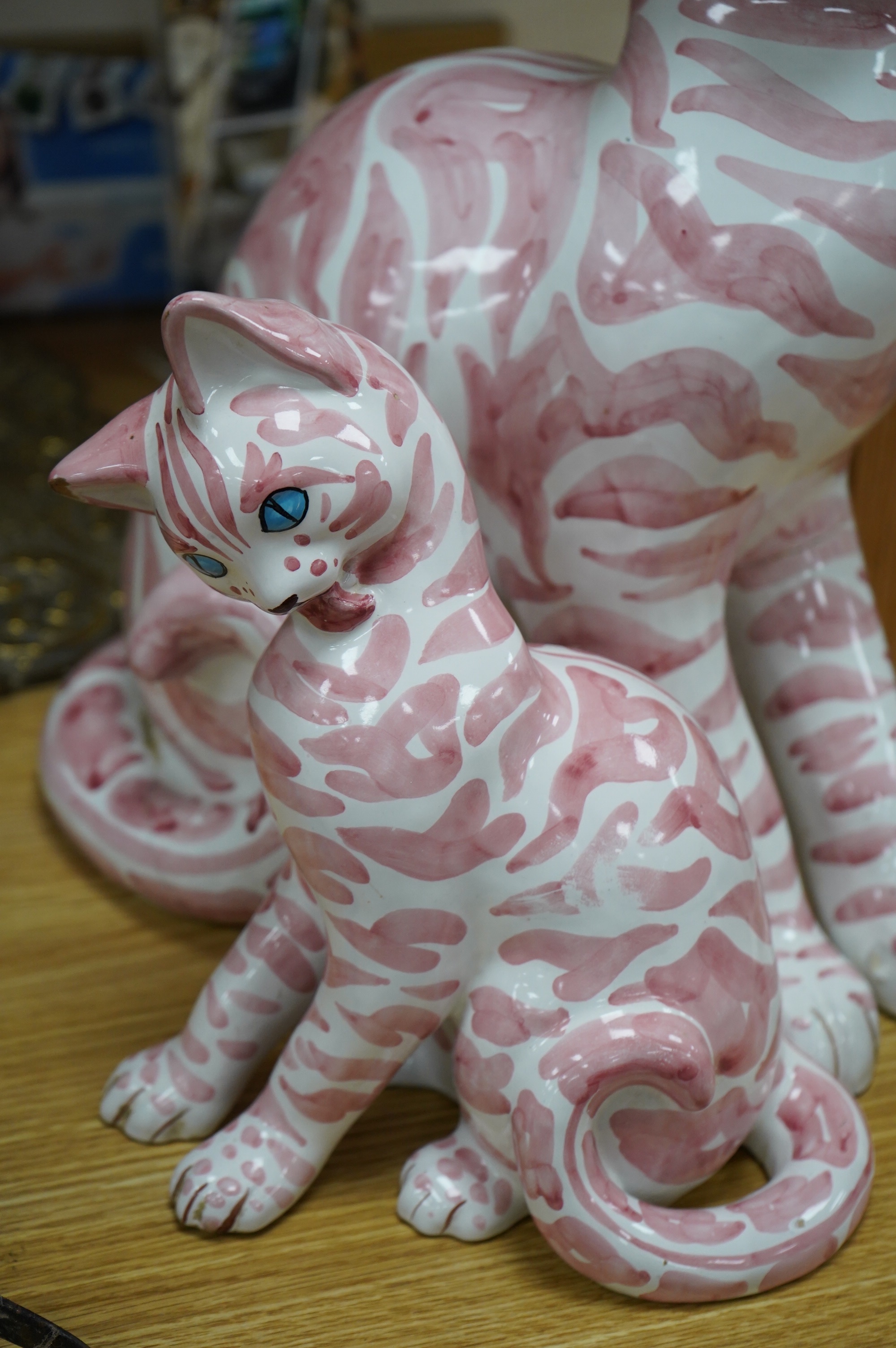 A large 1950's Italian pink maiolica seated cat and two smaller, largest 45cm. Condition - poor